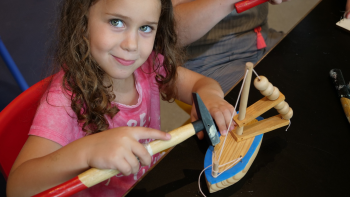 ילדה בונה סירה מעץ